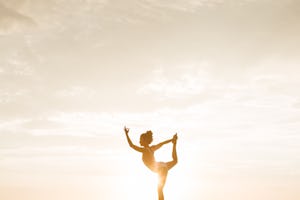 Woman in yoga pose with sun
